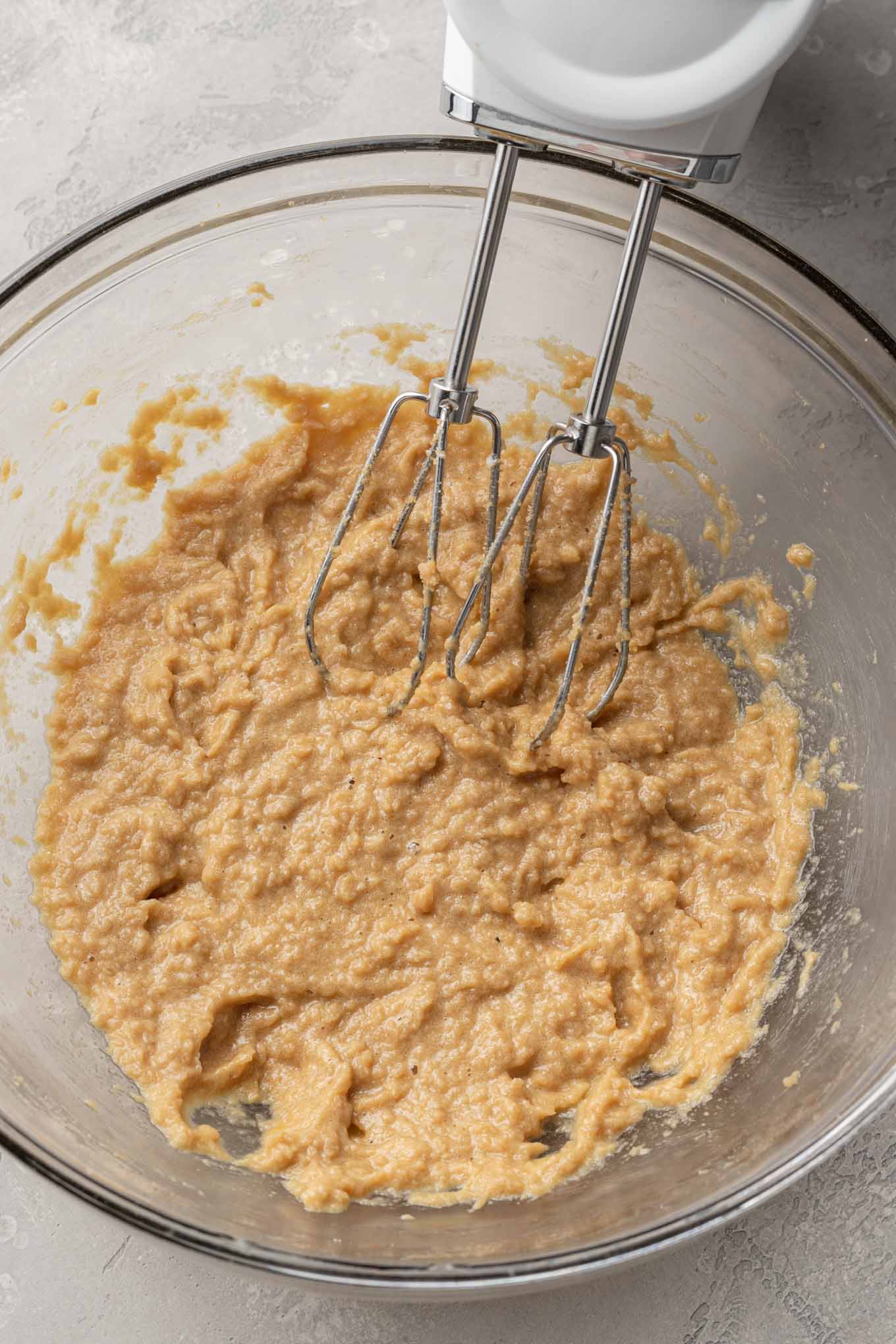 An overhead view of the wet ingredients for s'mores bars in a glass mixing bowl. 