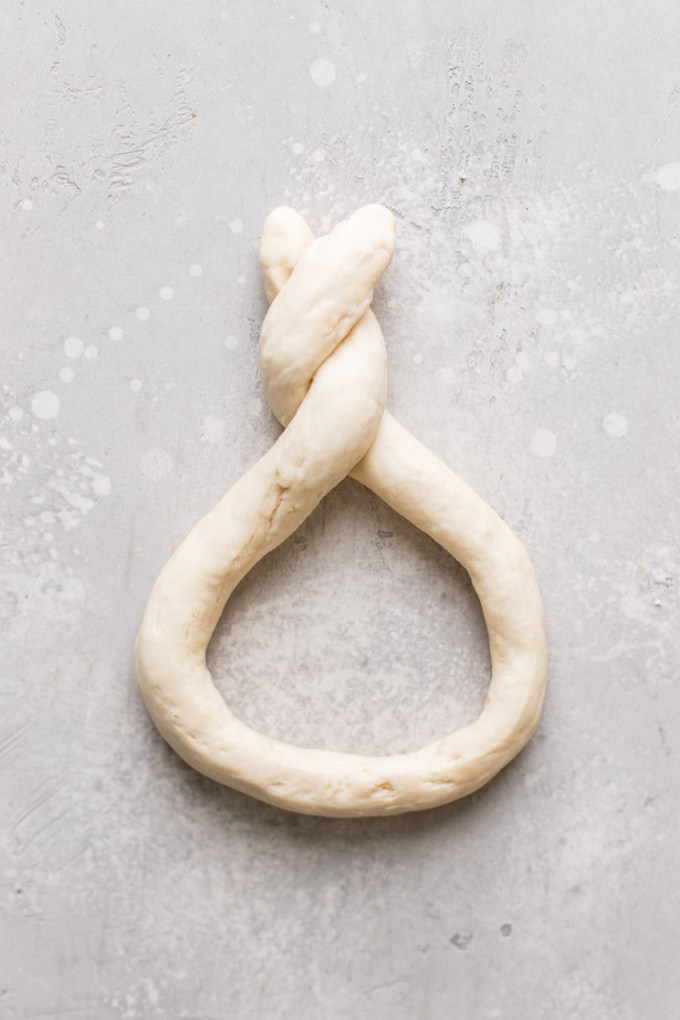 A roll of raw pretzel dough formed into a twisted pretzel shape.