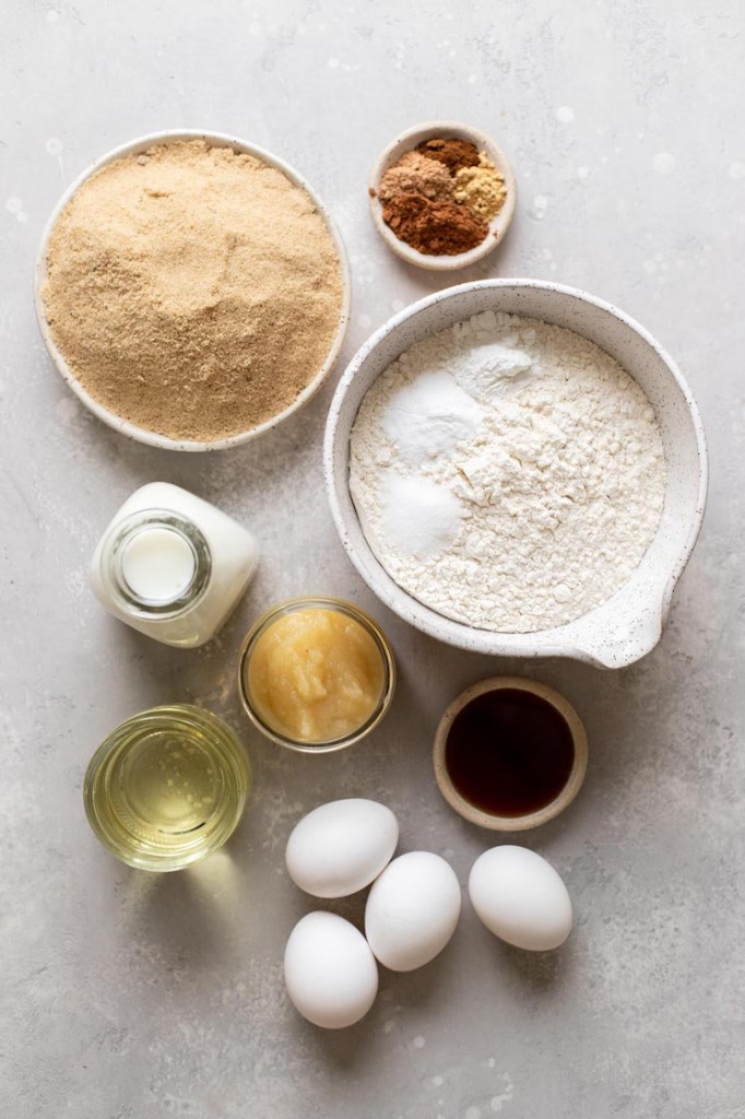 The ingredients needed to make spice cake laid out on a gray surface.