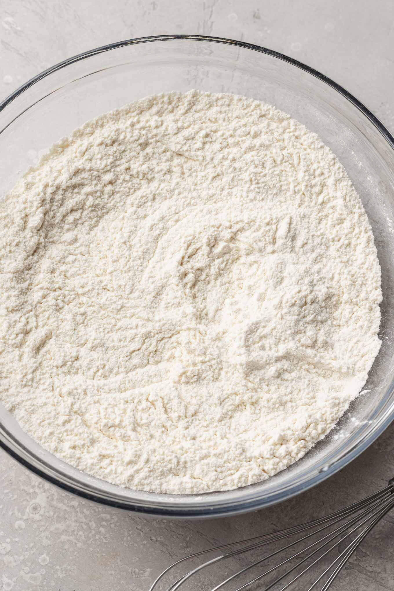 Flour, baking powder, and salt whisked together in a glass mixing bowl.