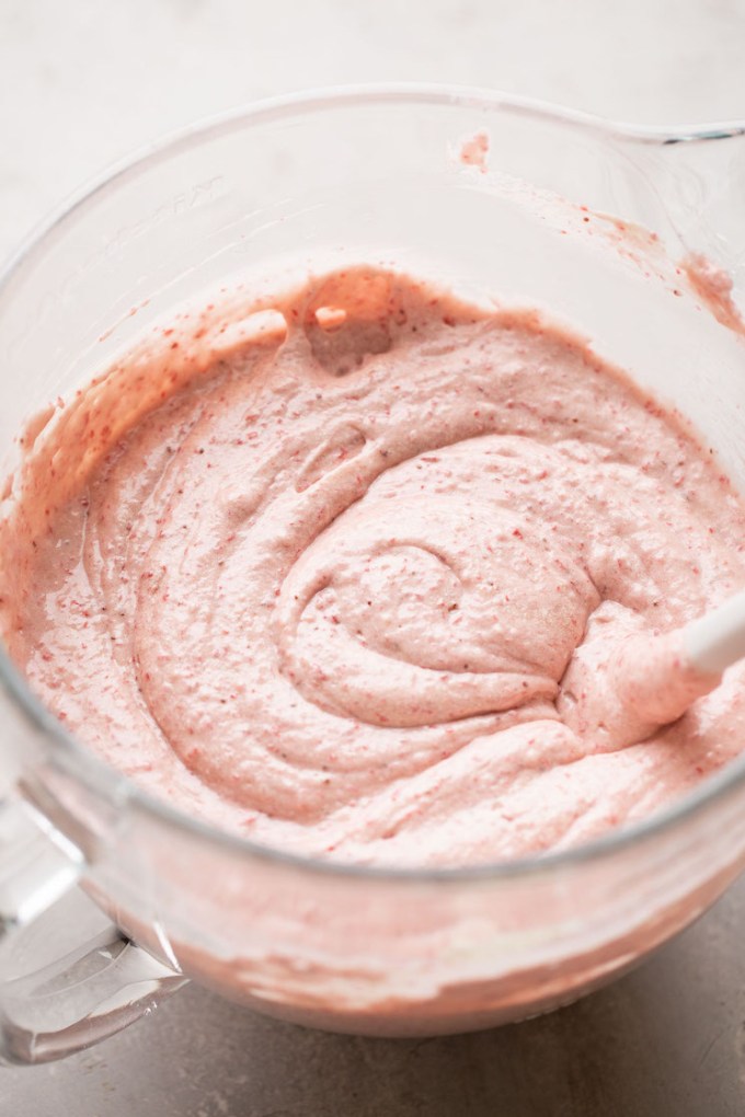 Strawberry cake batter mixed together in a glass mixing bowl.