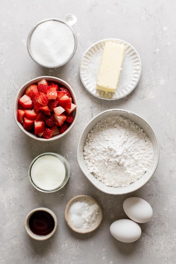 An overhead view of the ingredients needed to make strawberry cupcakes and strawberry frosting. 