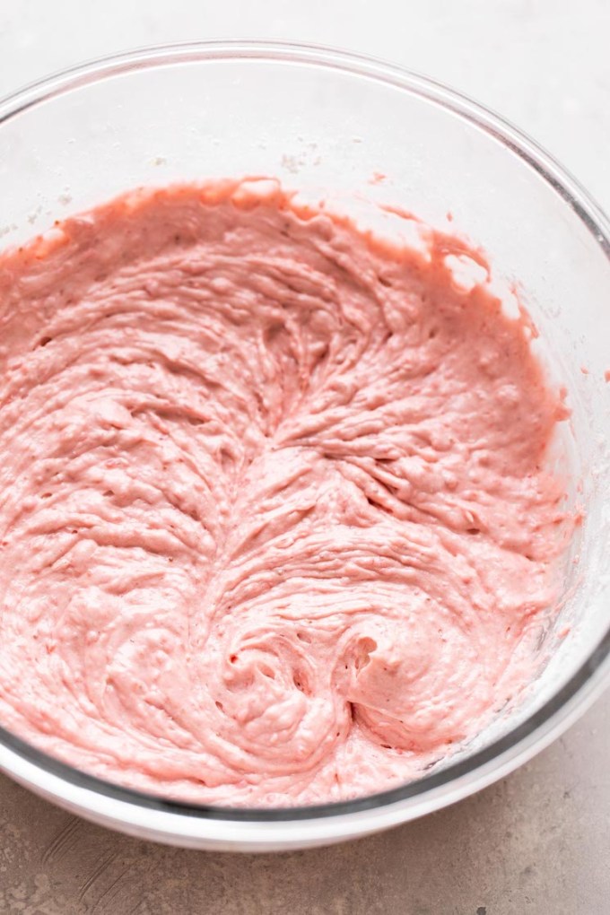 A glass mixing bowl of strawberry cupcake batter.