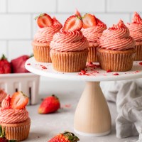 A side view of fresh strawberry cupcakes on a cake stand.