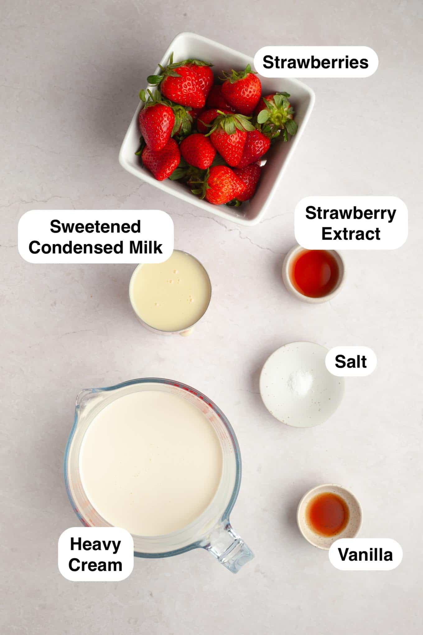 An overhead view of the ingredients needed to make homemade strawberry ice cream. 