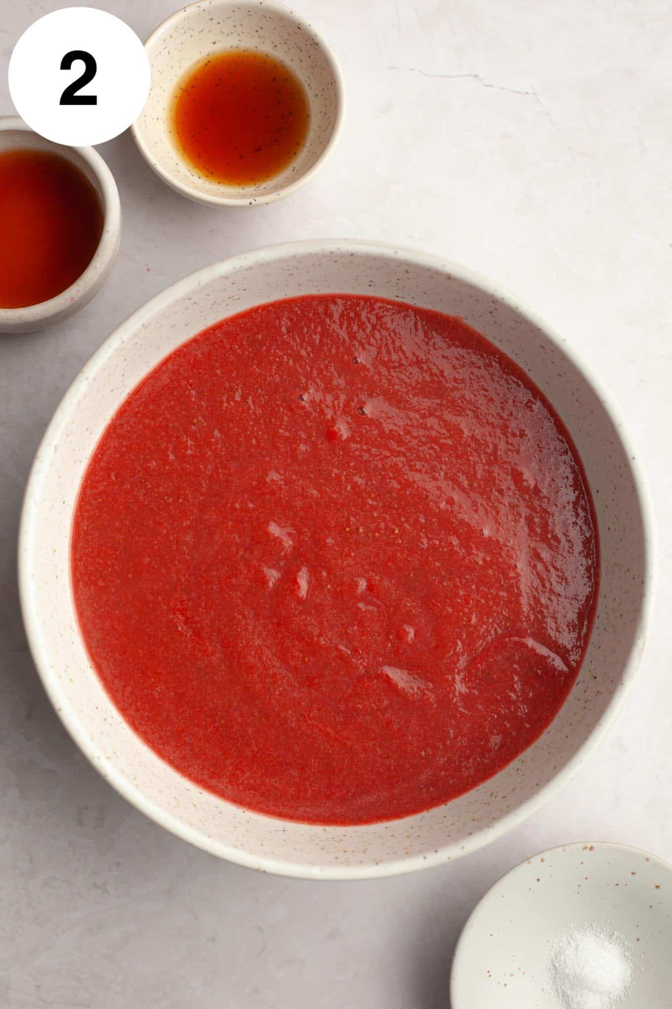 An overhead view of reduced strawberry puree in a bowl. 