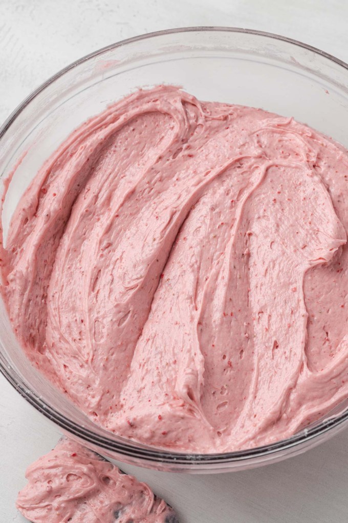 An overhead view of a glass mixing bowl of pound cake batter.