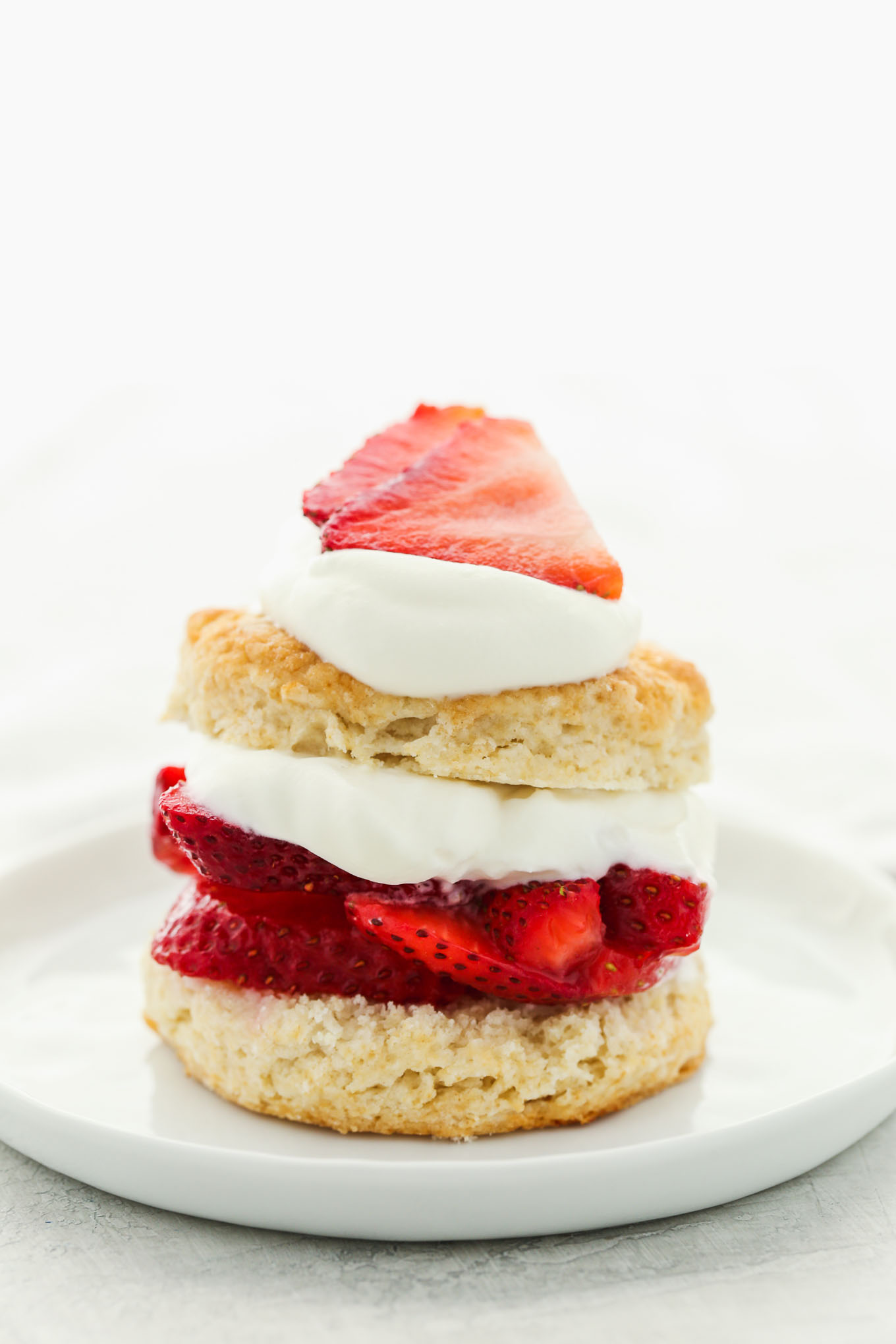 A close-up image showing the layers of the strawberry shortcake on a white plate.