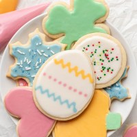 Several iced sugar cookies on a white plate.