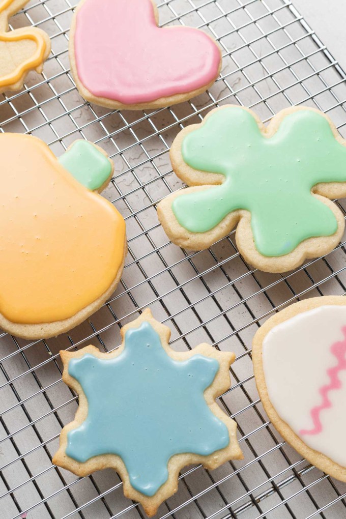 Iced cut out sugar cookies on a wire cooling rack.