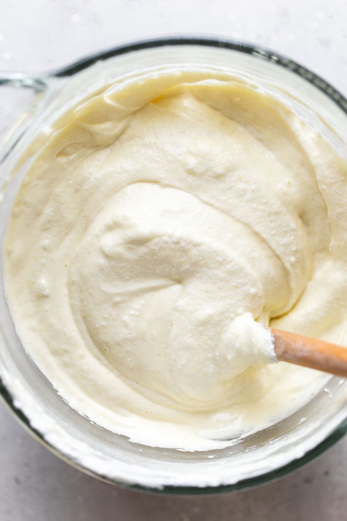 Overhead view of tres leches cake batter in a glass bowl with a spatula.