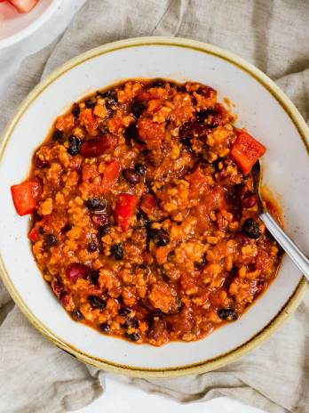 A bowl of turkey chili with a spoon resting in it.