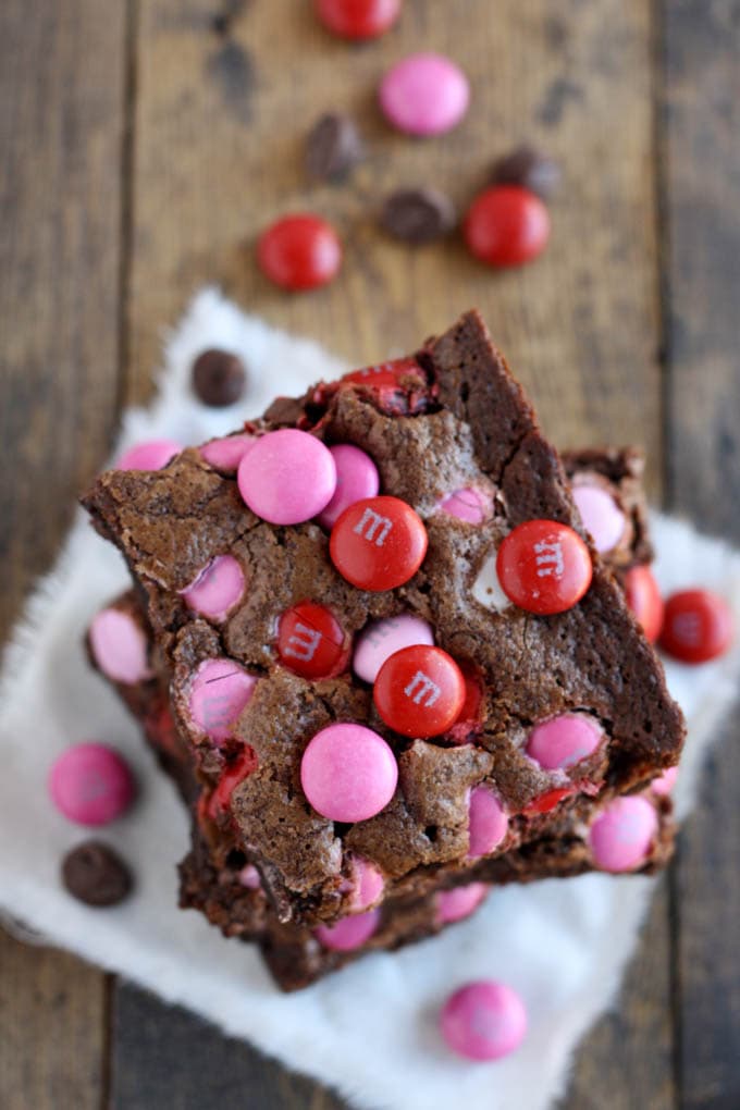 Overhead view of a stack of three Valentine's Day brownies on a square of fabric.