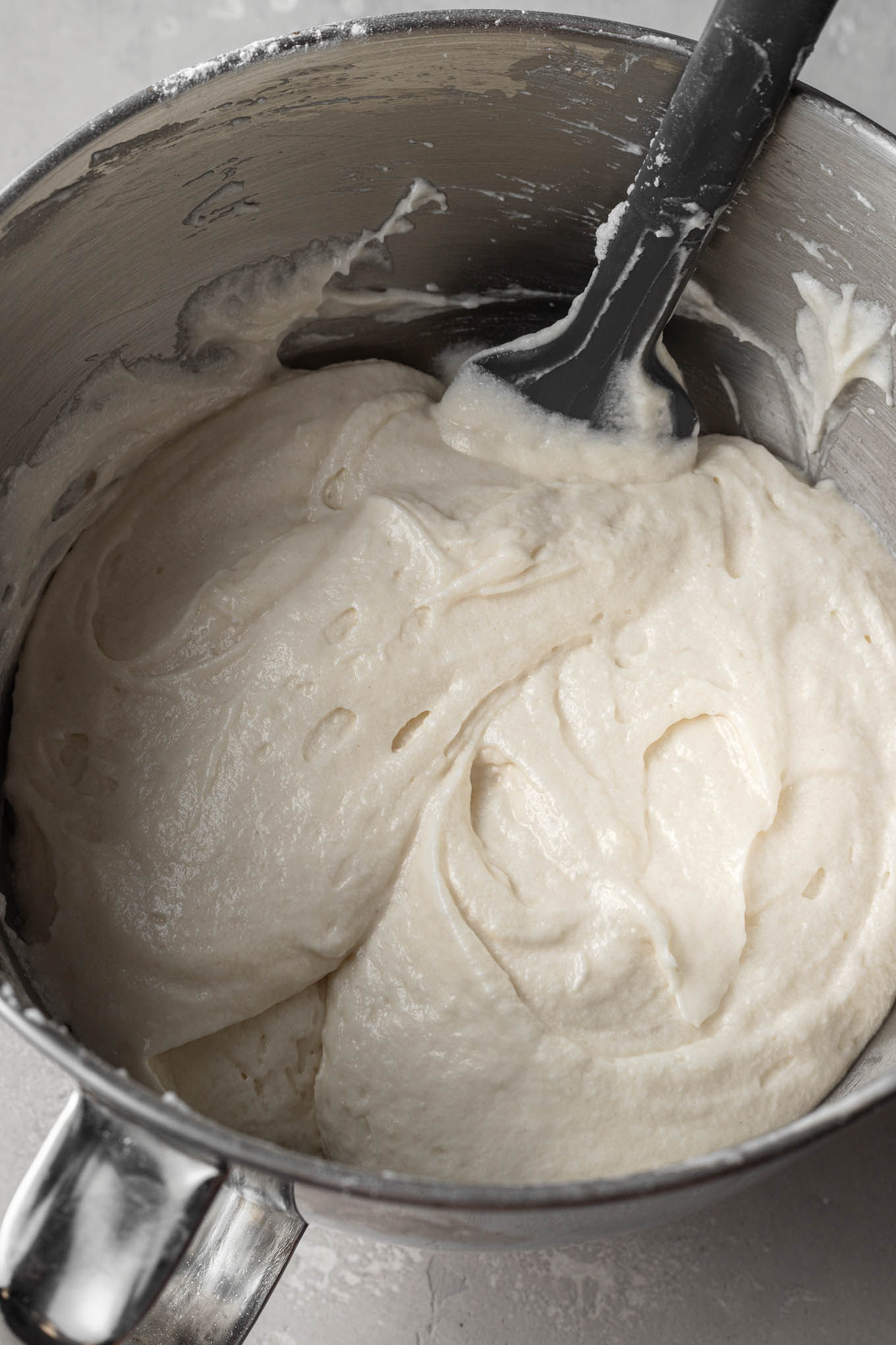 White cake batter in a mixing bowl, with egg whites folded in.