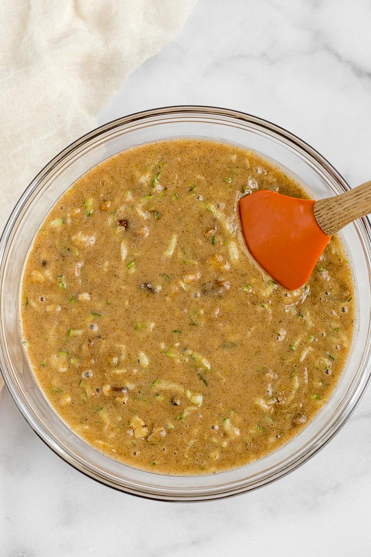 A glass bowl filled with the batter for zucchini bread.