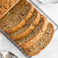 A sliced zucchini bread on top of a marble surface.